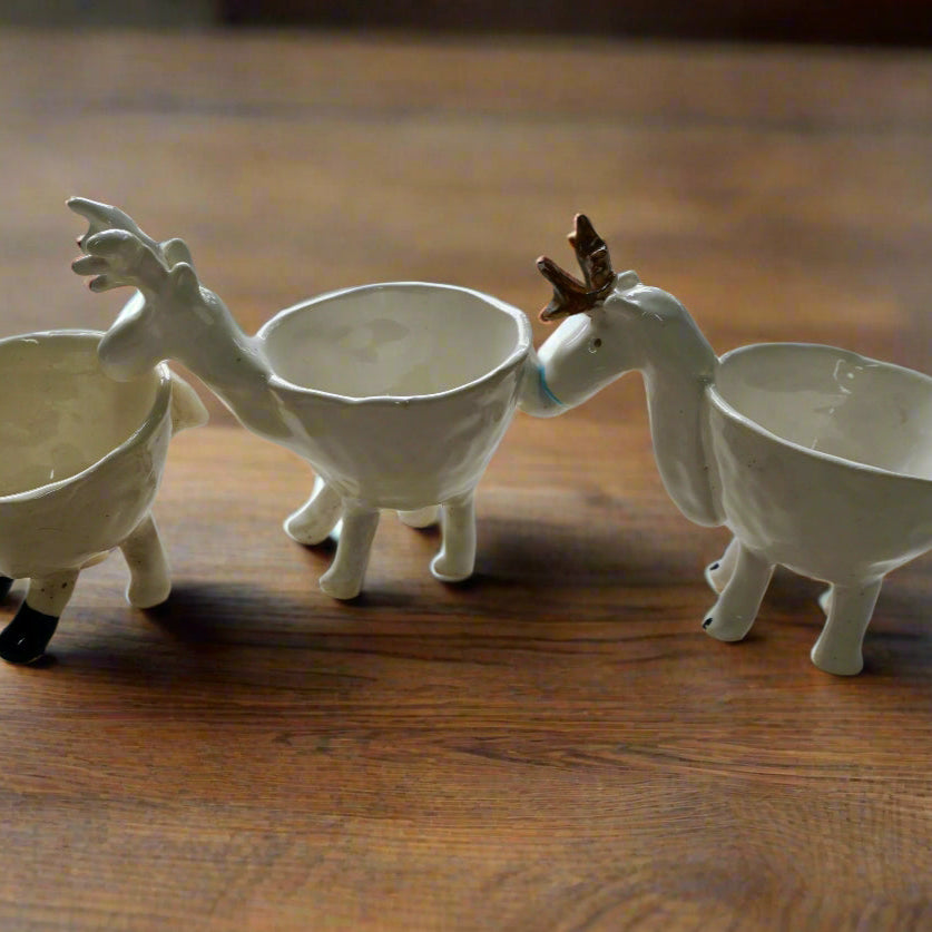Three ceramic snack bowls on a christmas fireplace 

